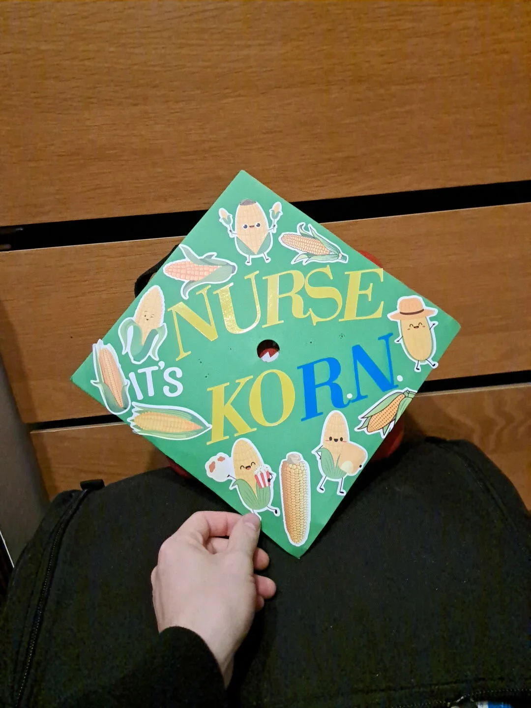 Shalom shows off his college graduation cap that features ‘Corn’ stickers on top.